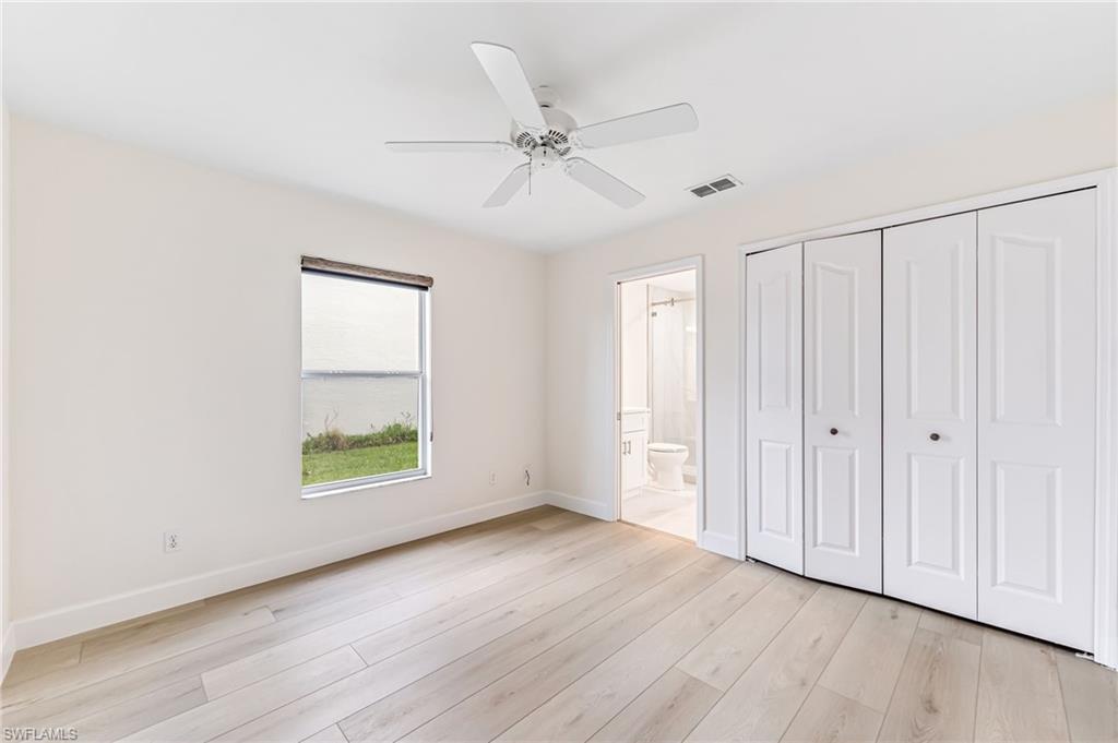 8562 Mustang Drive, Unit 31 Naples, FL 34113 - Photo 20 of 44 Unfurnished bedroom featuring a closet, connected bathroom, light wood finished floors, baseboards, and visible vents