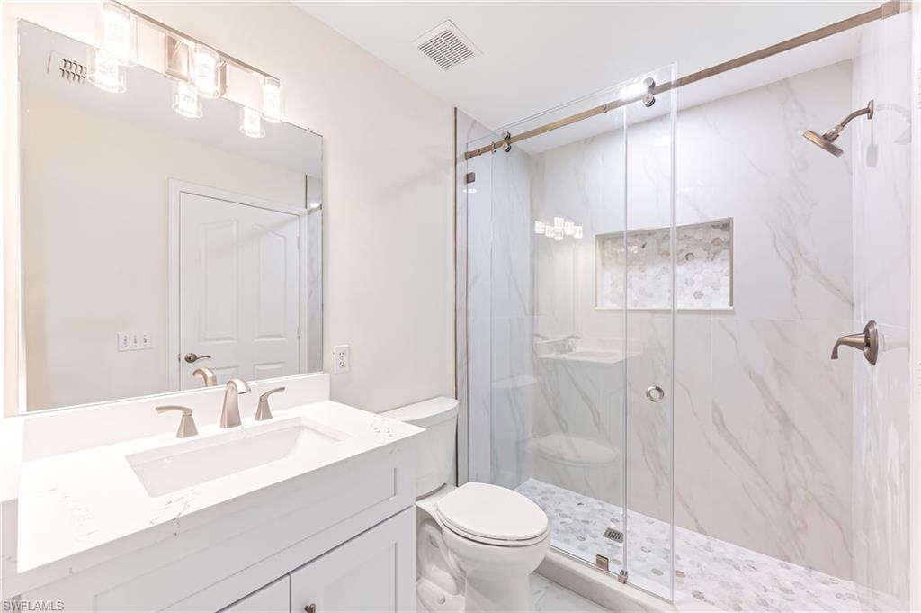 8562 Mustang Drive, Unit 31 Naples, FL 34113 - Photo 21 of 44 Full bathroom featuring vanity, toilet, a marble finish shower, and visible vents