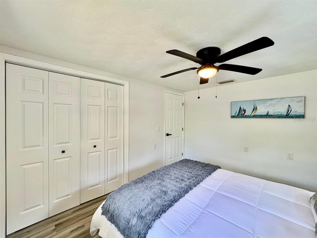 4282 Rudder Way New Port Richey, FL 34652 - Photo 18 of 34 a bedroom with a bed and a chandelier fan