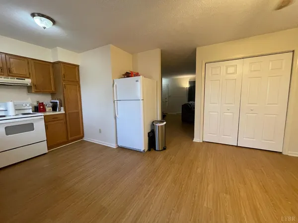 a view of kitchen with stainless steel appliances wooden floor and cabinets