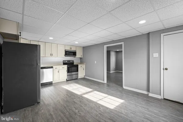 a kitchen with granite countertop a refrigerator and a stove top oven