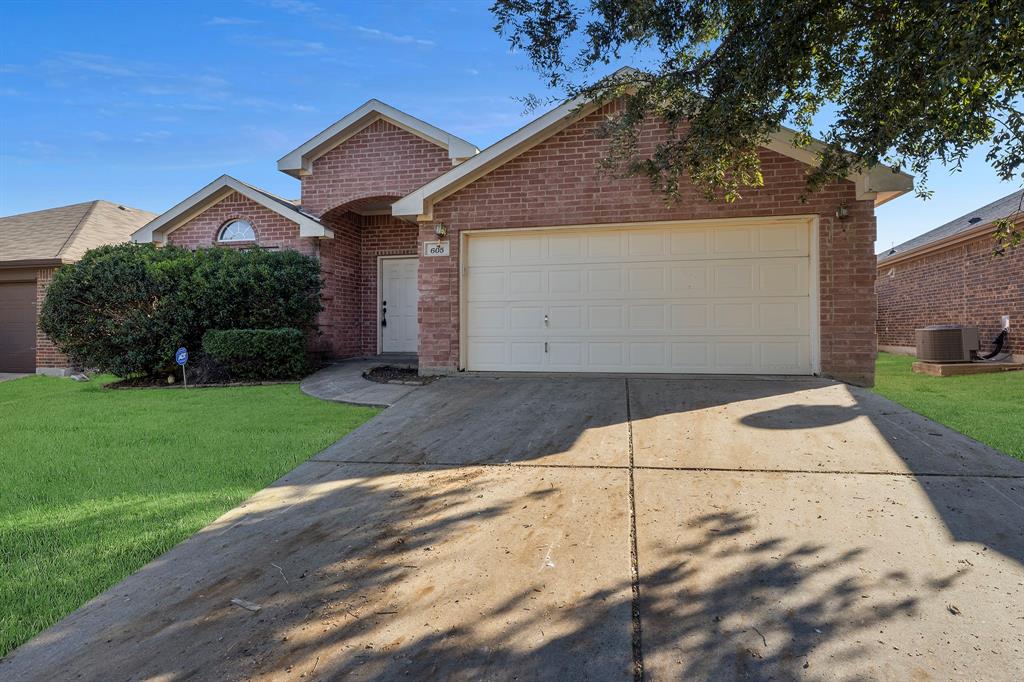 605 Clearbrook Street Azle, TX 76020 - Photo 31 of 33 Brick exterior with an arched entry, a prominent two-car garage, and a semicircular window accent