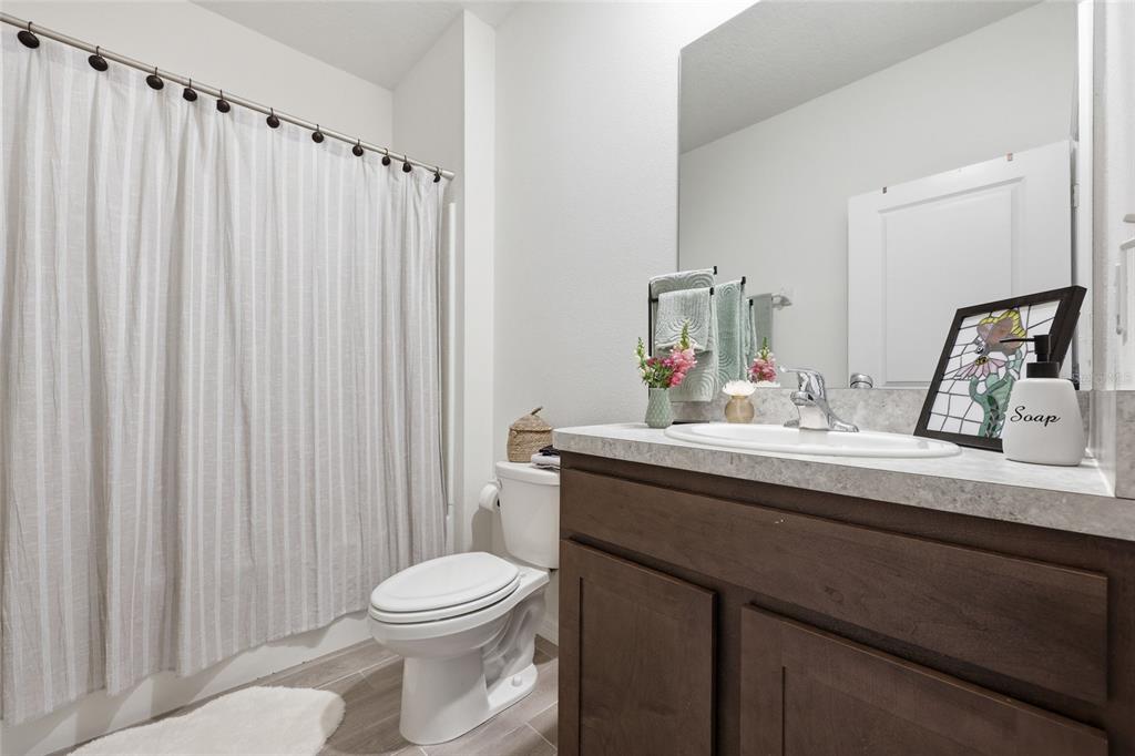 8261 Southwest 60th Avenue Gainesville, FL 32608 - Photo 14 of 34 a bathroom with a sink a toilet and shower curtain