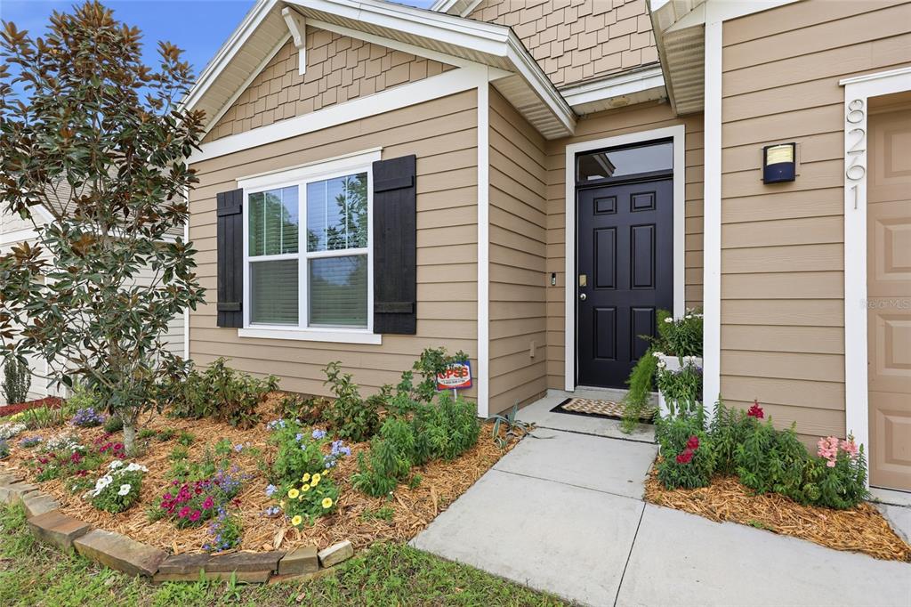 8261 Southwest 60th Avenue Gainesville, FL 32608 - Photo 7 of 34 a house with a flower garden in front of it
