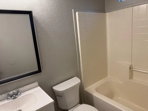 a white toilet sitting next to a bath tub