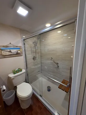 a bathroom with a toilet and a shower