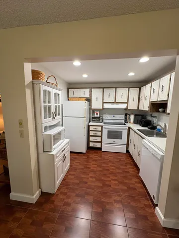 a kitchen with granite countertop a refrigerator and a stove