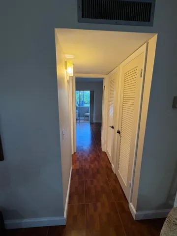a view of a hallway with wooden floor