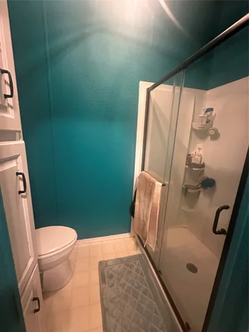 a bathroom with a toilet and a shower