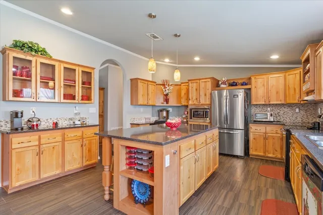 a kitchen with stainless steel appliances granite countertop a stove and wooden cabinets