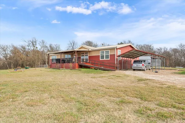 a front view of a house with a big yard with wooden fence