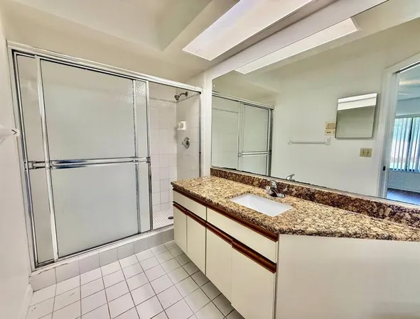 a bathroom with a granite countertop sink and a mirror