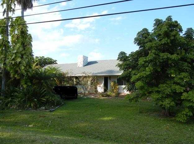 9759 Sandy Run Road Jupiter, FL 33478 - Photo 1 of 7 a front view of a house with a yard and a garden