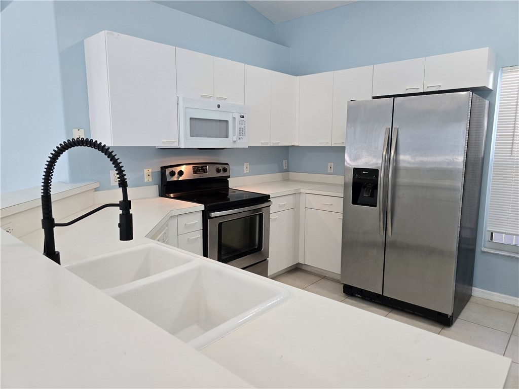 481 10th Place Vero Beach, FL 32960 - Photo 6 of 20 a kitchen with a refrigerator sink and cabinets