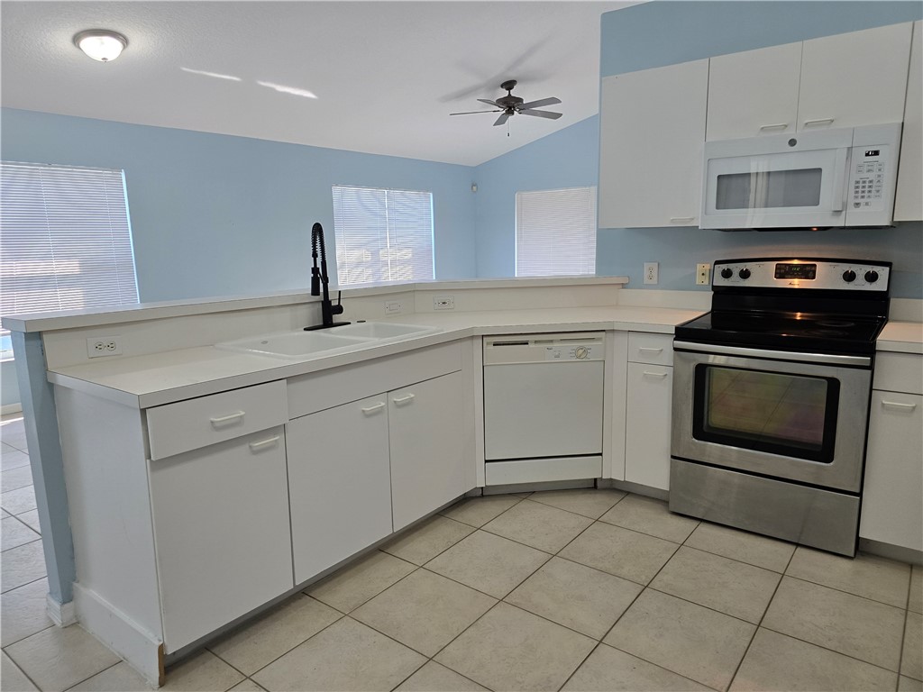 481 10th Place Vero Beach, FL 32960 - Photo 7 of 20 a kitchen with a stove sink and cabinets