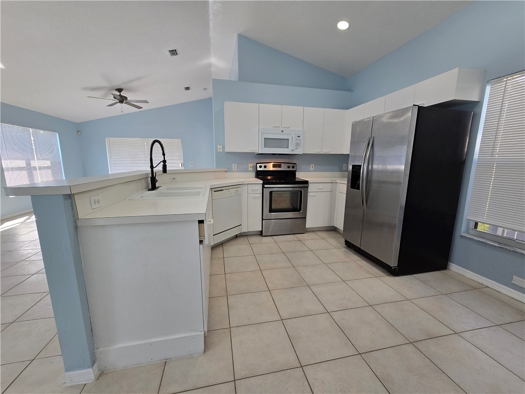 481 10th Place Vero Beach, FL 32960 - Photo 8 of 20 a kitchen with a sink a refrigerator and cabinets
