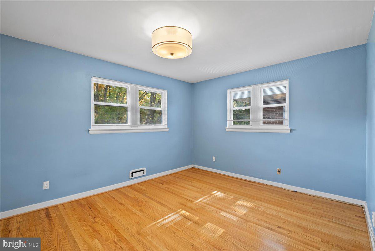 4411 Harrison Street Northwest Washington, DC 20015 - Photo 19 of 38 a view of a bedroom with wooden floor and window