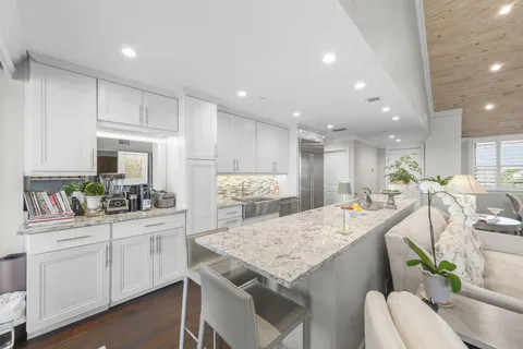 a kitchen with white cabinets and chairs