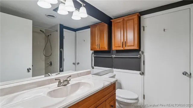 a bathroom with a sink a toilet and a mirror