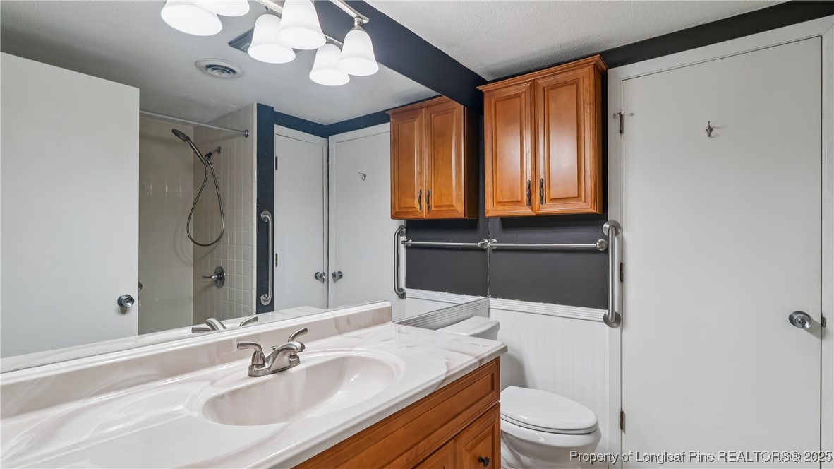 115 Beulah Hill Road South, Unit 111 Pinehurst, NC 28374 - Photo 12 of 32 a bathroom with a sink a toilet and a mirror