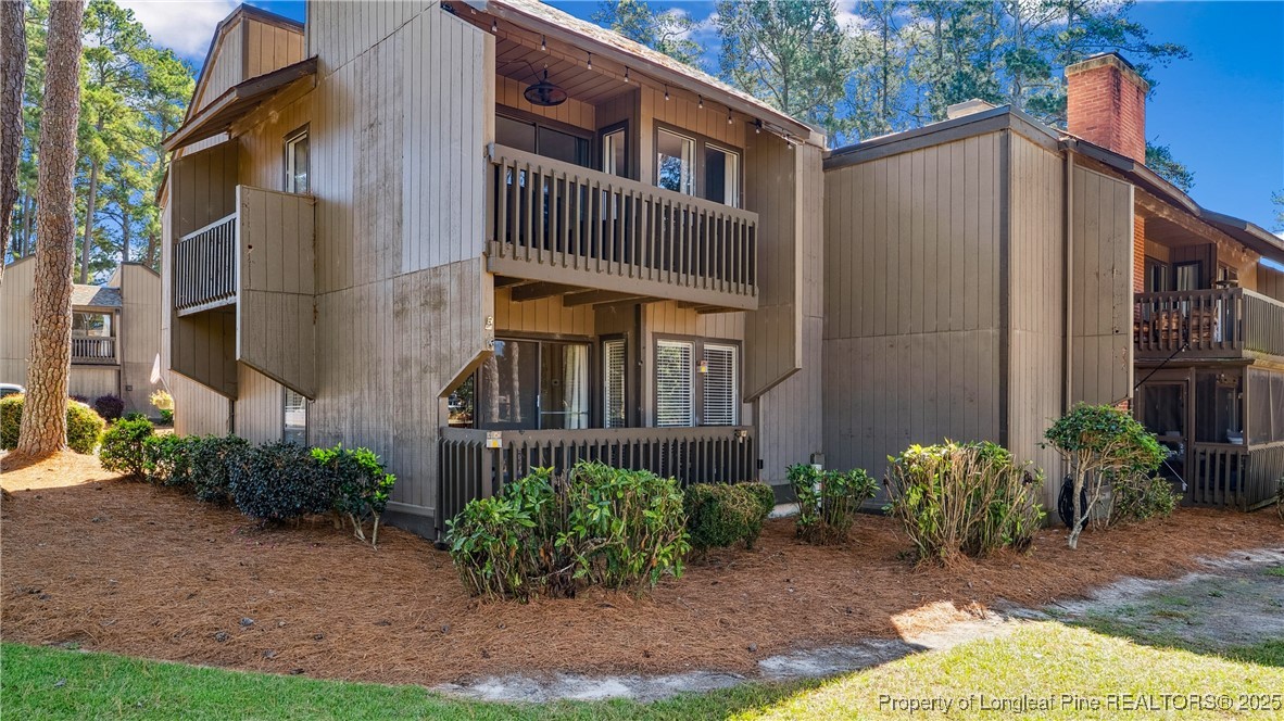 115 Beulah Hill Road South, Unit 111 Pinehurst, NC 28374 - Photo 20 of 32 a view of a house with brick walls plants and covered with wooden fence