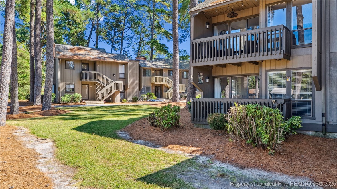 115 Beulah Hill Road South, Unit 111 Pinehurst, NC 28374 - Photo 22 of 32 a view of a brick house with a yard and plants