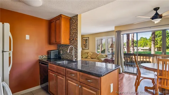 a kitchen with a granite countertop sink and a refrigerator