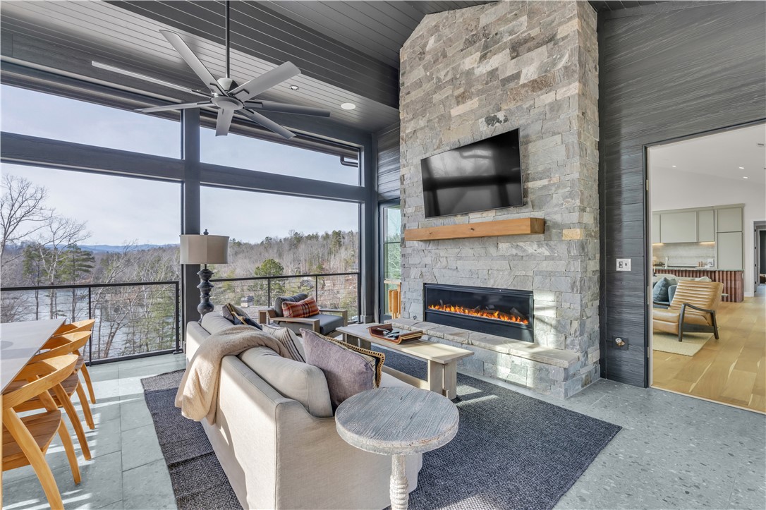 127 Crosswind Court Sunset, SC 29685 - Photo 25 of 49 This bright living space features a captivating stone fireplace, expansive windows, and picturesque outdoor views.