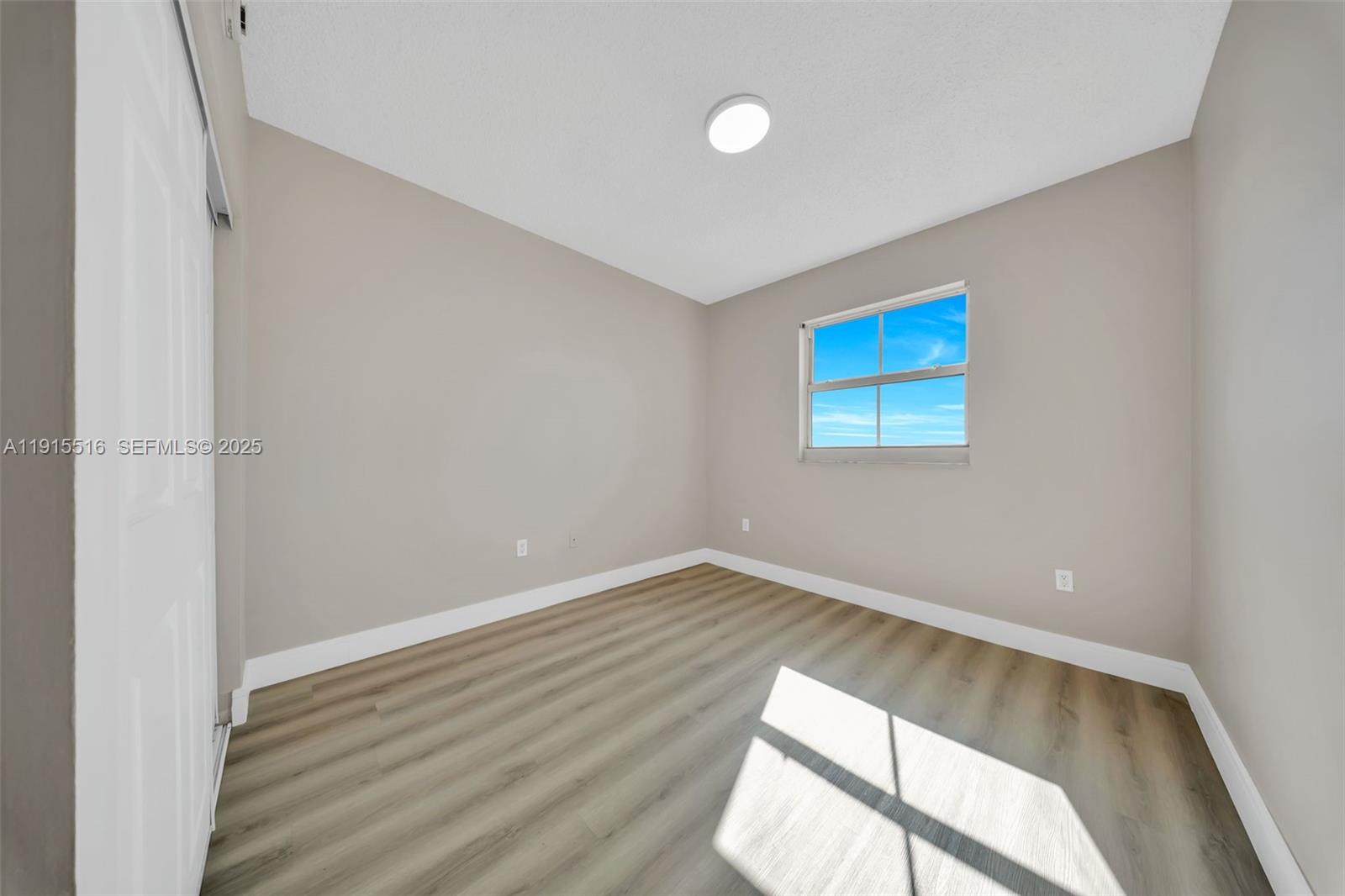 185 Southeast 14th Terrace, Unit 2008 Miami, FL 33131 - Photo 11 of 26 an empty room with wooden floor and windows