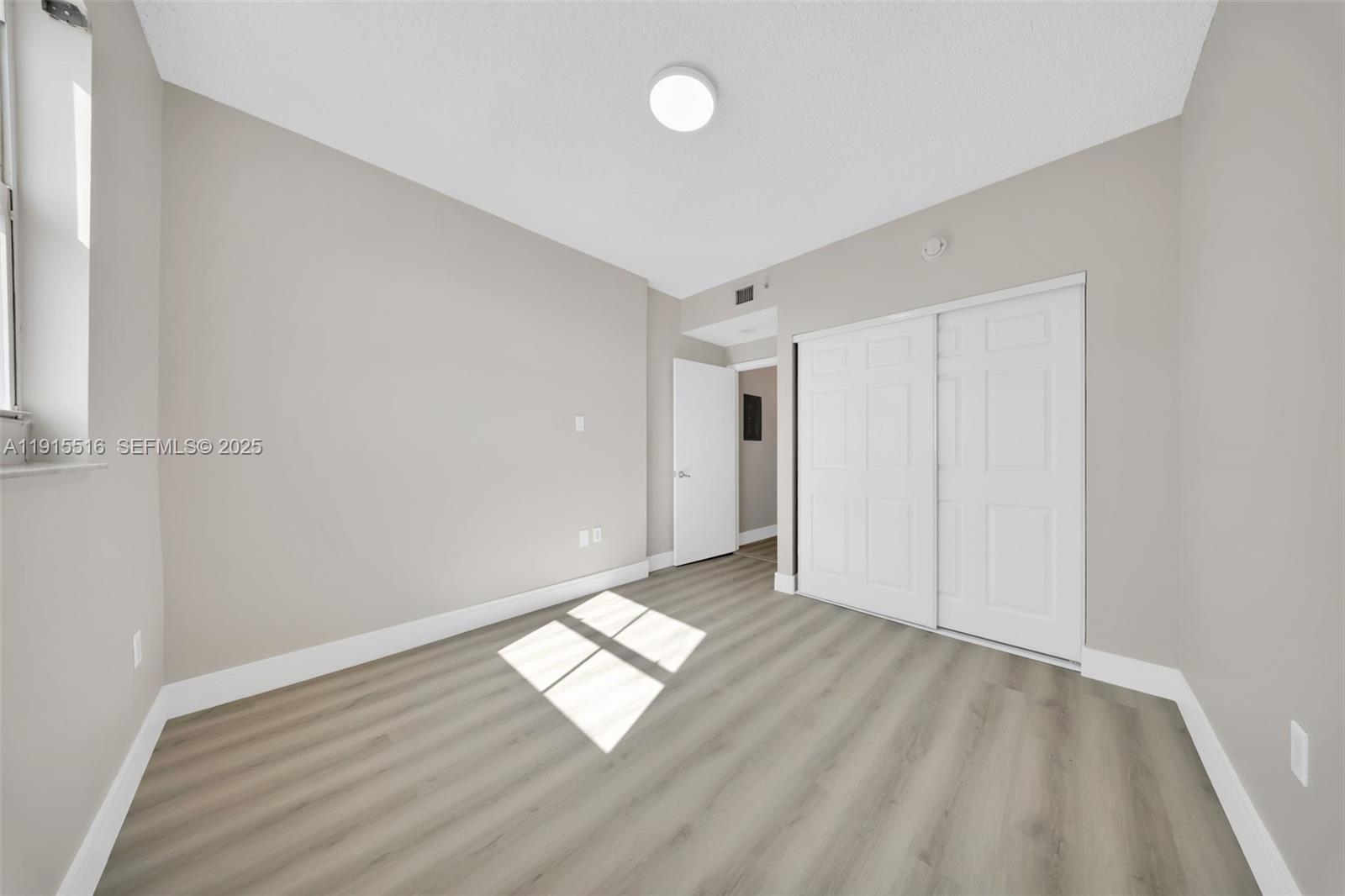 185 Southeast 14th Terrace, Unit 2008 Miami, FL 33131 - Photo 12 of 26 an empty room with wooden floor and windows