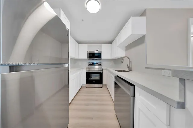 a kitchen with cabinets and stainless steel appliances