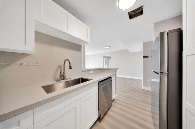 a kitchen with refrigerator and cabinets