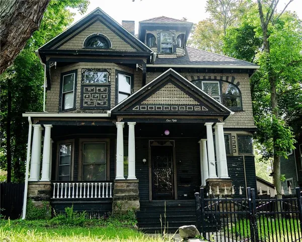 a view of staircase with lots of frames on wall and a window