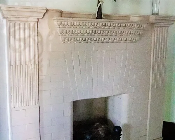 a view of a livingroom with wooden floor fireplace and window
