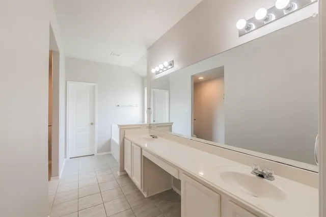 a room with a sink vanity and mirror
