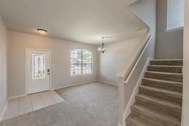 a view of an empty room with wooden floor and windows