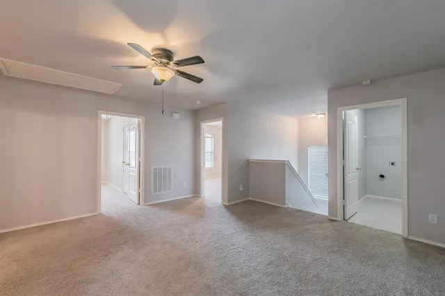 a view of an empty room and a ceiling fan