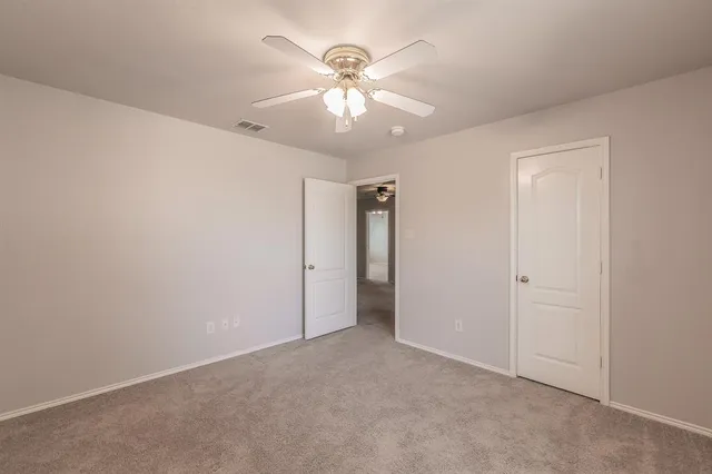 an empty room with fan and windows