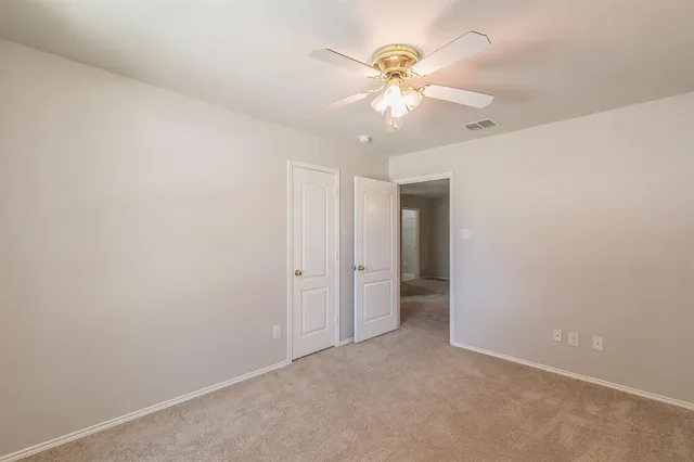 an empty room with a fan and a fan