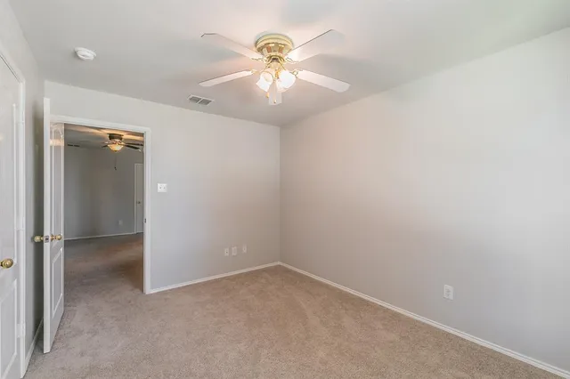 an empty room with fan and a ceiling fan