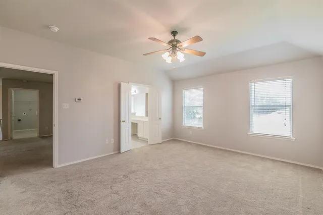 an empty room with windows and fan