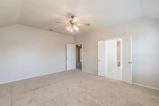 an empty room with chandelier fan
