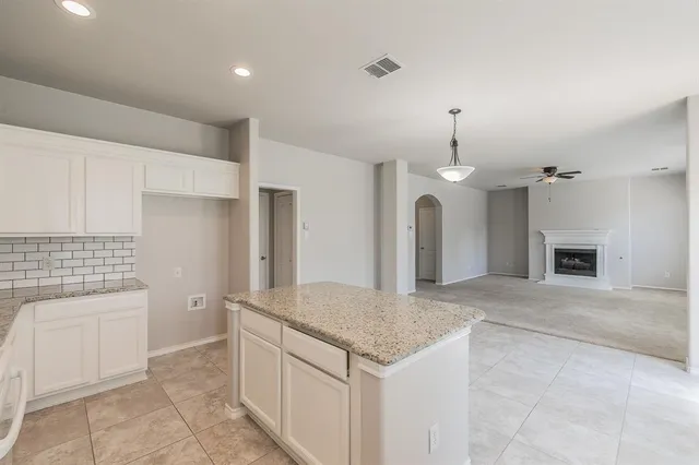 a kitchen with a sink chandelier and fireplace