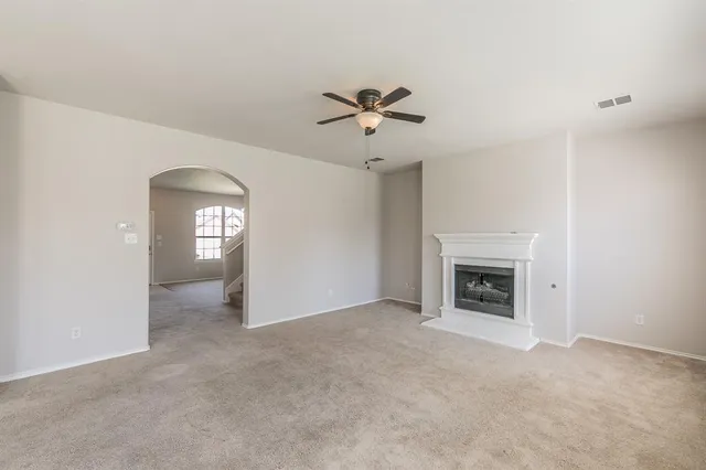a view of a livingroom with a fireplace and a chandelier fan