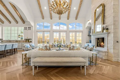 a living room with furniture a large window and a fireplace