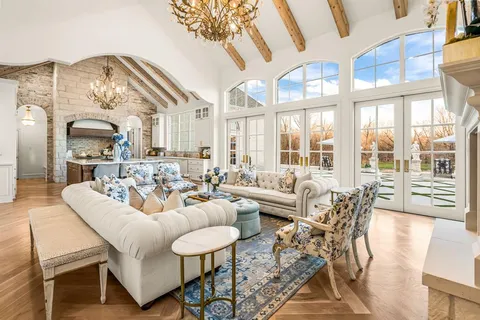 a living room with furniture fireplace and a large window