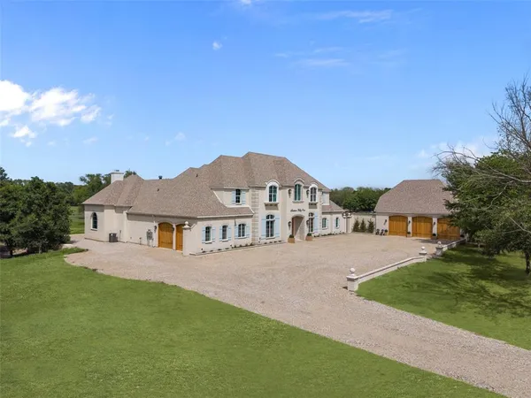 front view of a house with a yard and an trees