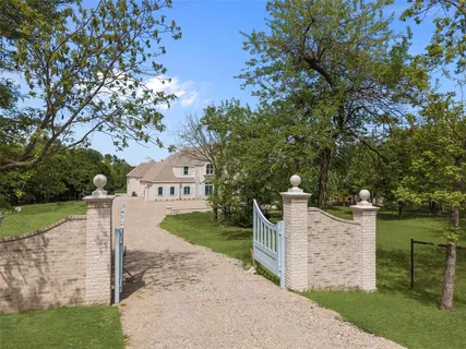 front view of a house with a yard and an trees