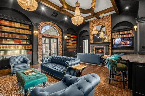 a living room with furniture a fireplace and a floor to ceiling window