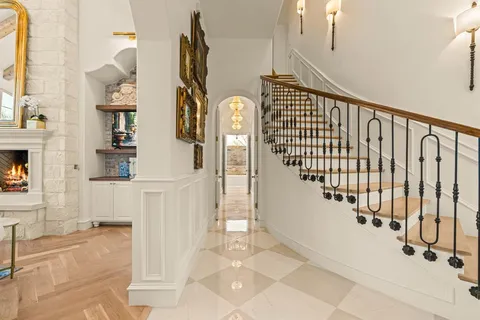 a view of staircase with lots of frames on wall and a potted plant